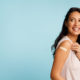 Woman Showing Vaccinated Arm With Bandage After Injection, Blue Background