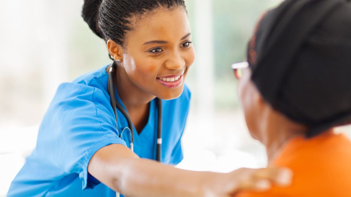 african medical nurse comforting senior patient