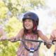 three girls smiling on their bicycles