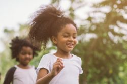 kids running surrounded by trees