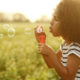 child blowing out bubbles