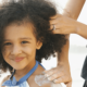 mother applying lotion on daughter's shoulder