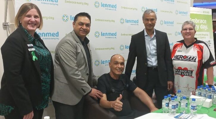 Patient giving thumbs up with doctors alongside him