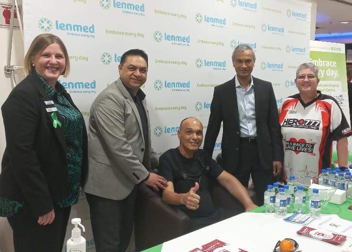 Patient giving thumbs up with doctors alongside him