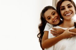 smiling woman piggybacking her daughter