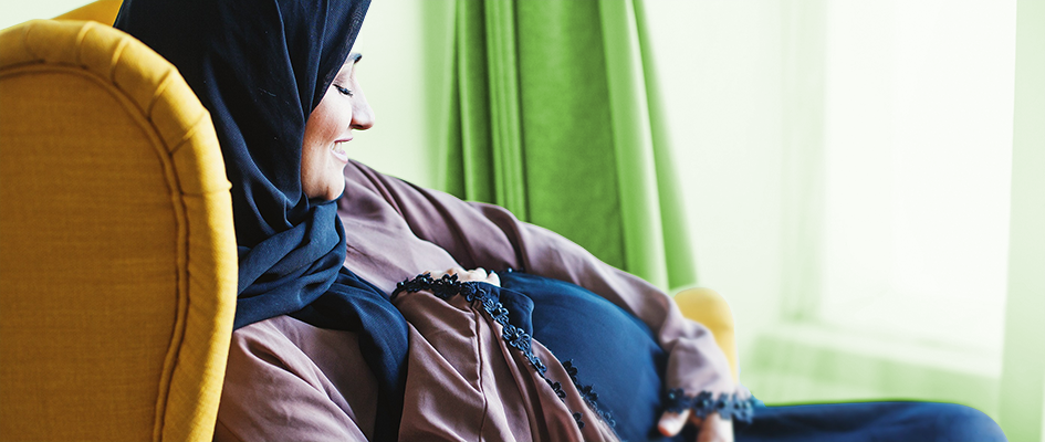muslim pregnant woman observing belly
