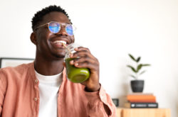 african-american-man-drinks-green-juice-with-bambo-2022-08-10-20-05-16-utc
