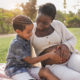 African pregnant mother and mixed race son touching belly