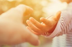 woman reaching out to hold a hand