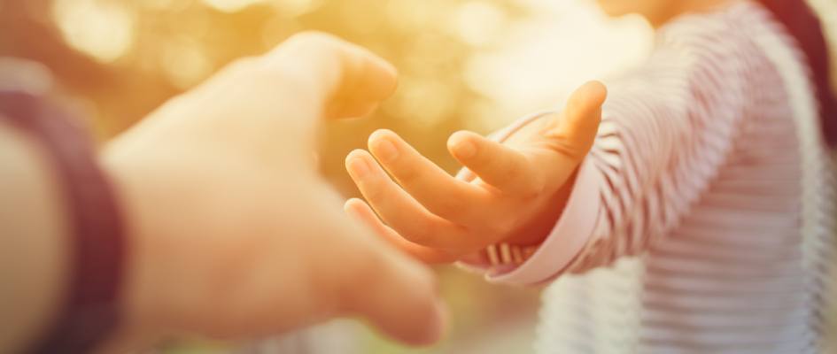 woman reaching out to hold a hand