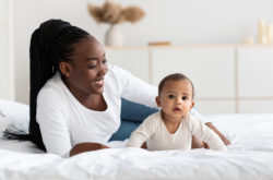 African American woman playing with her adorable black baby