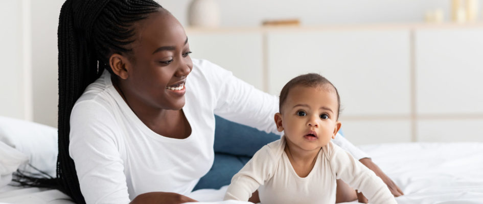 African American woman playing with her adorable black baby