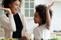 mother and daughter high-fiving in the kitchen