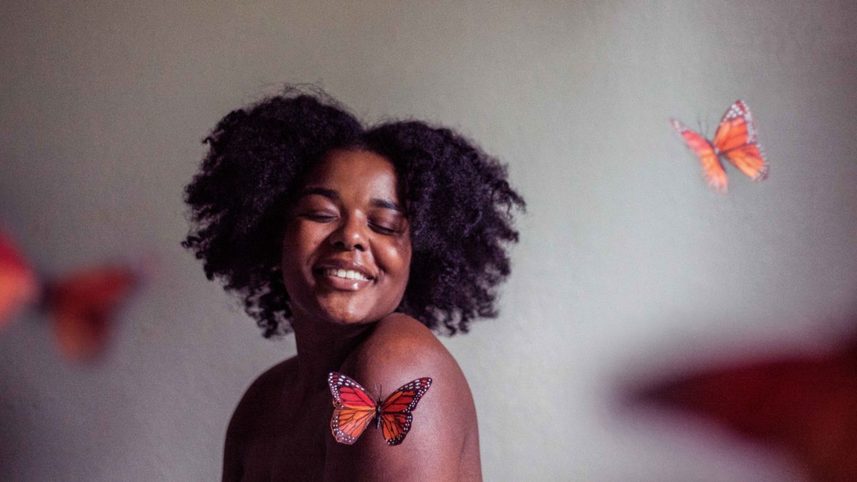 woman smiling with butterflies around her