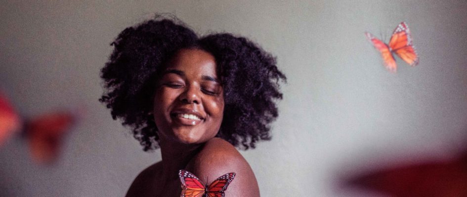 woman smiling with butterflies around her