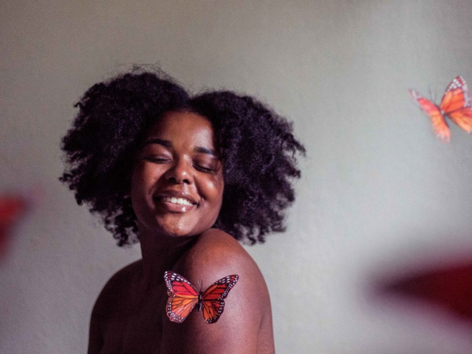 woman smiling with butterflies around her