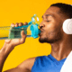 man with headphones on drinking water