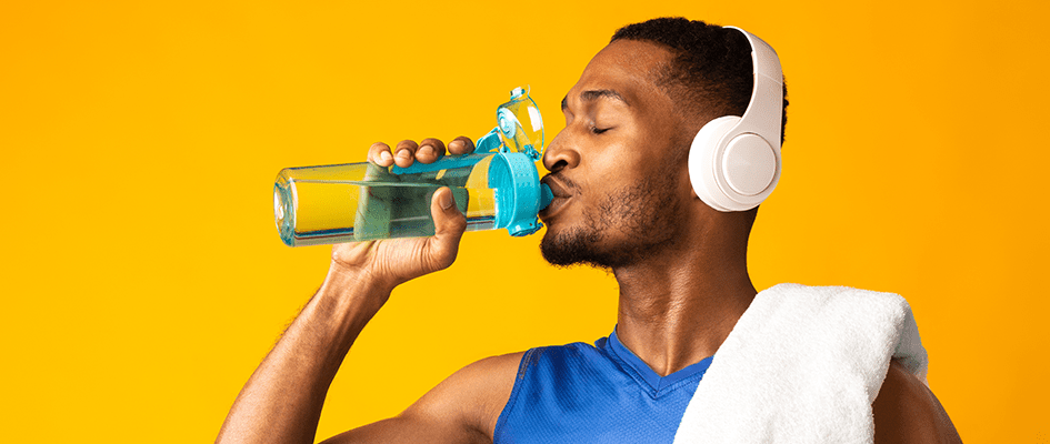 man with headphones on drinking water