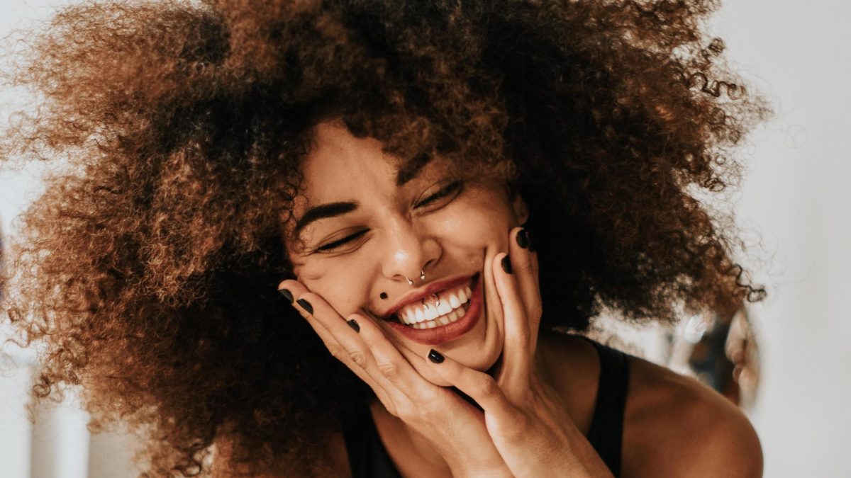 woman smiling with hands on her face