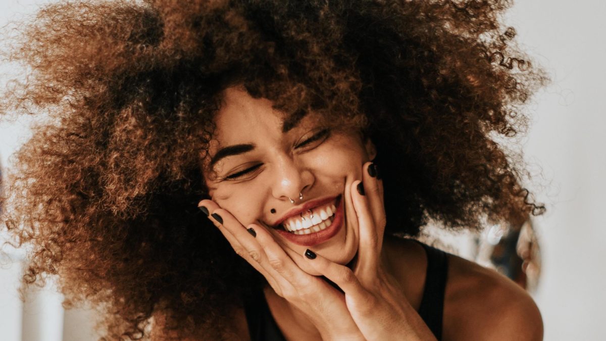 woman smiling with hands on her face