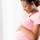standing pregnant woman observing her belly