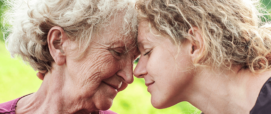 grandmother and daughter foreheads against each other