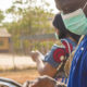 black people, travellers, wearing face masks, standing outdoors