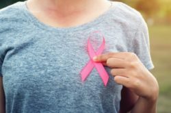 women holding cancer ribbon on left side of the chest