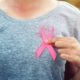 women holding cancer ribbon on left side of the chest