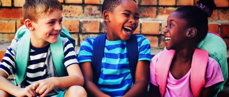 three toddlers laughing with backpack on