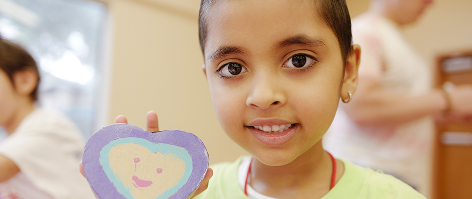 child showing heart-shaped cookie