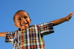 Happy Child smiling with arms in the air