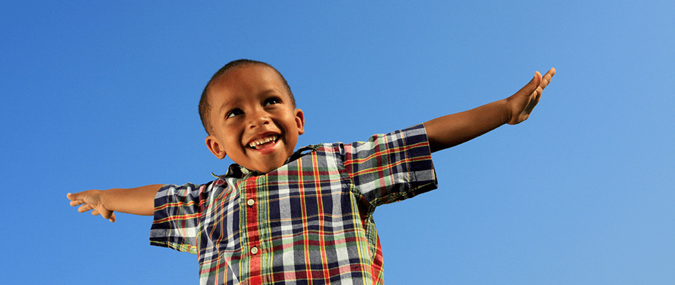 Happy Child smiling with arms in the air